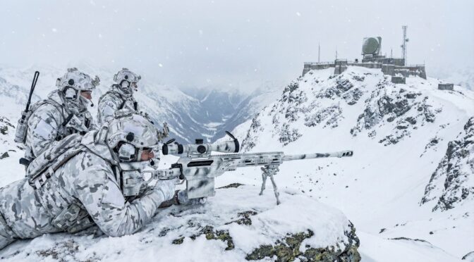 Camouflaged sniper team with Cadex CDX-50 Tremor rifle in snowy mountain terrain.
