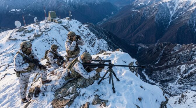 Mountain sniper team with ZVI Falcon rifle on snowy peak near communications tower.