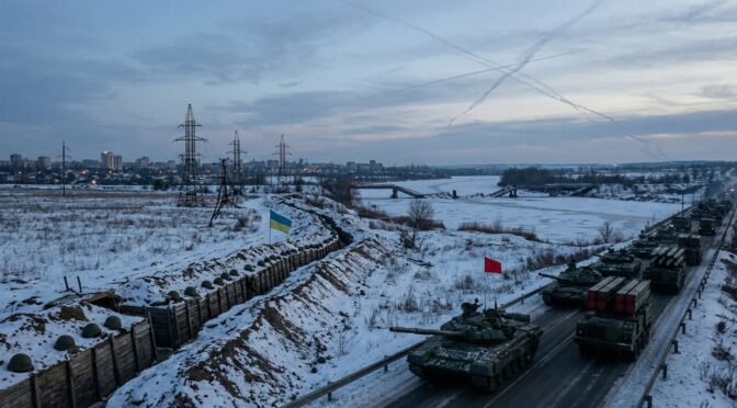 Ukrainian tanks and military vehicles positioned near a snowy front line, with trenches and the national flag.