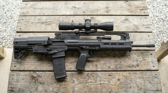 Springfield Hellion bullpup rifle with Nightforce scope on a wooden table.