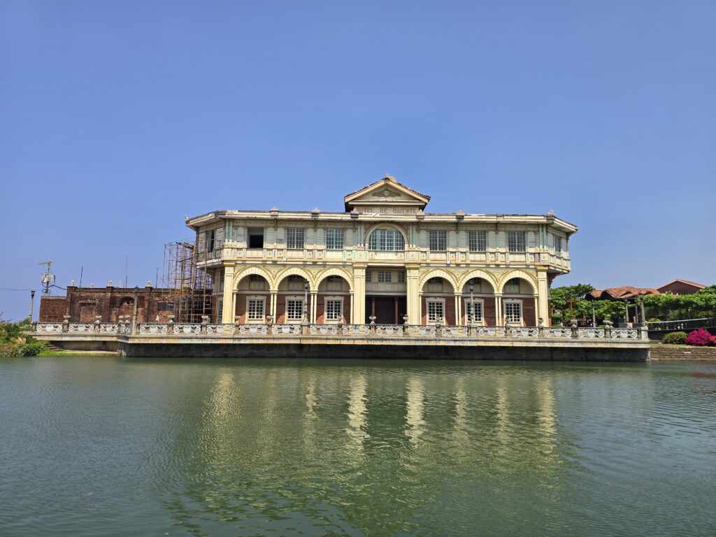 Hotel de Oriente in the Philippines, a colonial-style building reflected in the water.