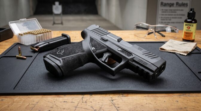 Taurus TX 22 pistol with ammunition and range accessories on a wooden table.