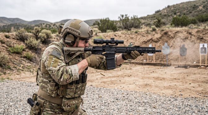 Soldier in tactical gear fires an AR-15 rifle at an outdoor shooting range.