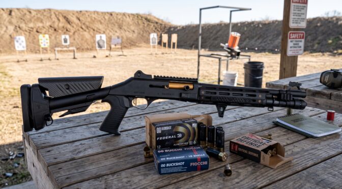 Black tactical shotgun with ammo boxes and targets on a wooden table at a shooting range.
