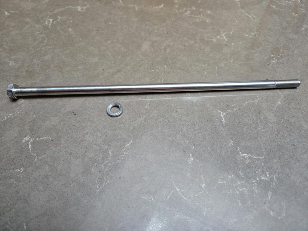 Long silver bolt and washer on a textured surface