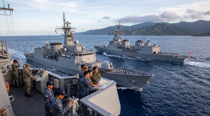 Philippine and Japanese naval officers review a map on a ship during a joint exercise.
