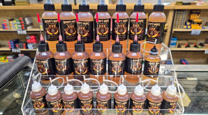 Ronin's Grips gun oil bottles on display rack