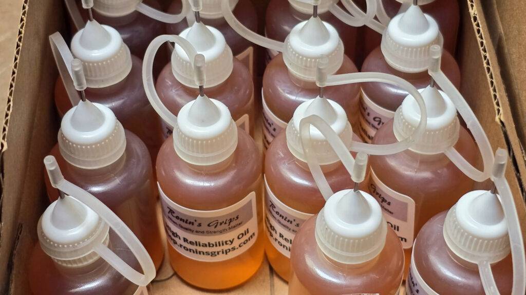 Ronin's Grips reliability oil bottles with white caps and clear applicators