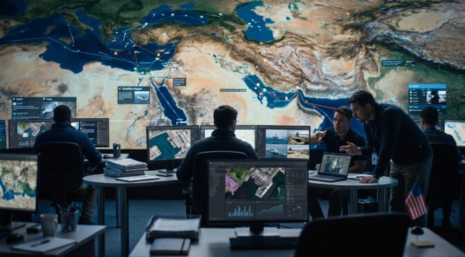 Military analysts monitor global operations on a large interactive map display.